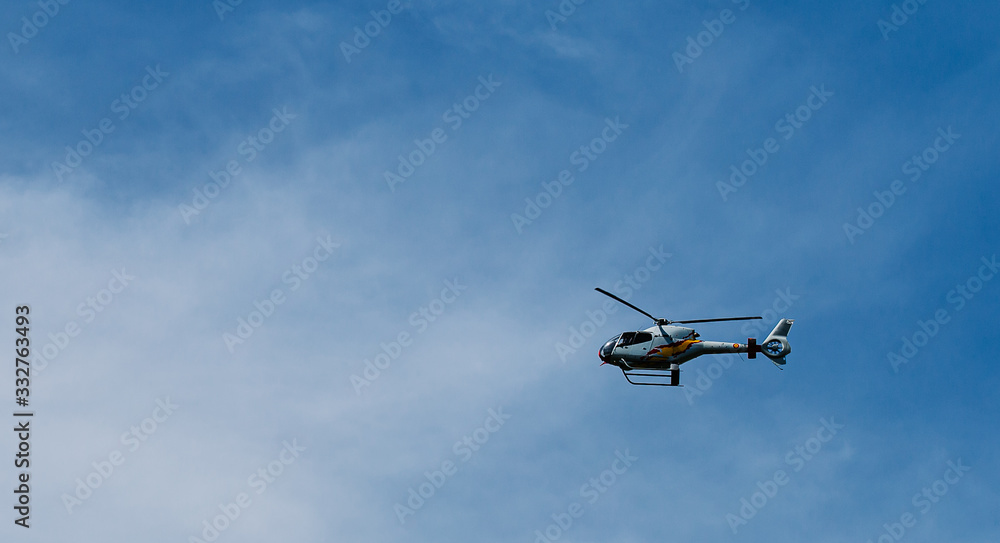 Military helicopter stationary in the blue sky with copy space Military helicopter stationary in the blue sky with copy space