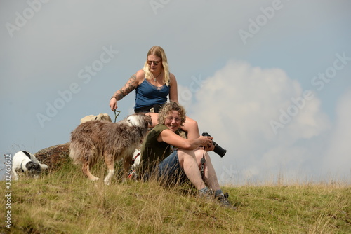 Rast . Zwei Frauen mit Hunden und Kamera sitzen auf einem Felsen