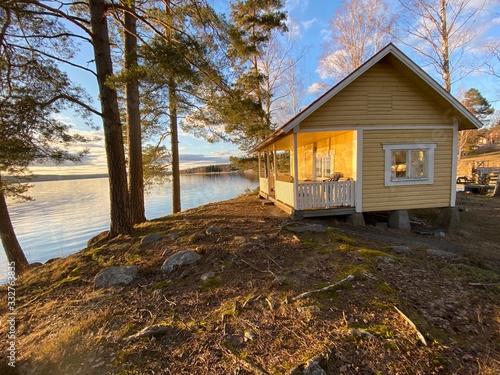 Yellow cottage by a lake photo