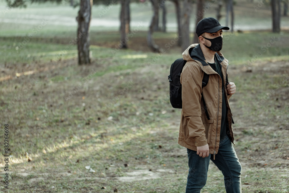 man in medical mask walking in park away from people. man breath fresh air outdoor man in medical mask walking in park away from people. man breath fresh air outdoor
