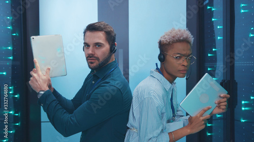Φωτογραφία Professional multi-race armed spies on secret operation sneaking in server room walking aiming tablets like guns working in team
