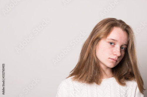 Sad teenager girl. Studio image of a cute young girl on a gray background.