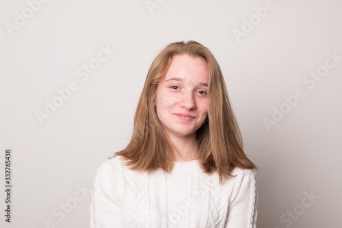 Cheerful teen girl. Studio image of a cute smiling young girl on a gray background.
