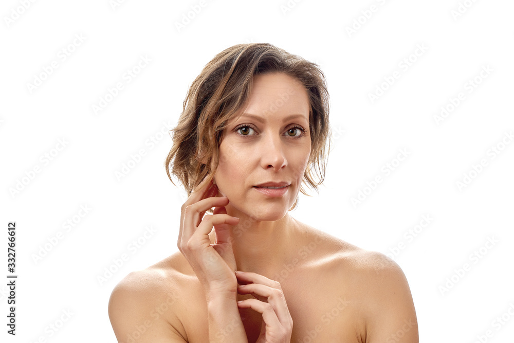 Fototapeta premium Beautiful young woman with a short haircut is looking at the camera. Clean skin. Naked to the shoulders posing. isolated white background.