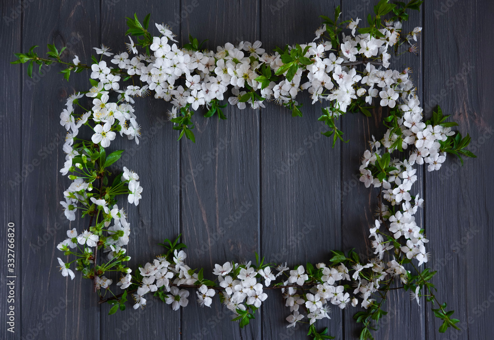 Spring frame for text. Banner design for spring promotion. White cherry flowers on a wooden background with a place for an inscription. Frame for text from fresh flowers. Spring frame for text. Banner design for spring promotion. White cherry flowers on a wooden background with a place for an inscription. Frame for text from fresh flowers.
