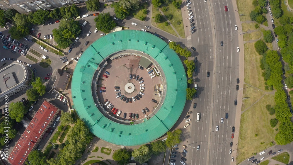 interesting round shape of the building with a green roof, view from the drone, smooth cinematic movement of the drone