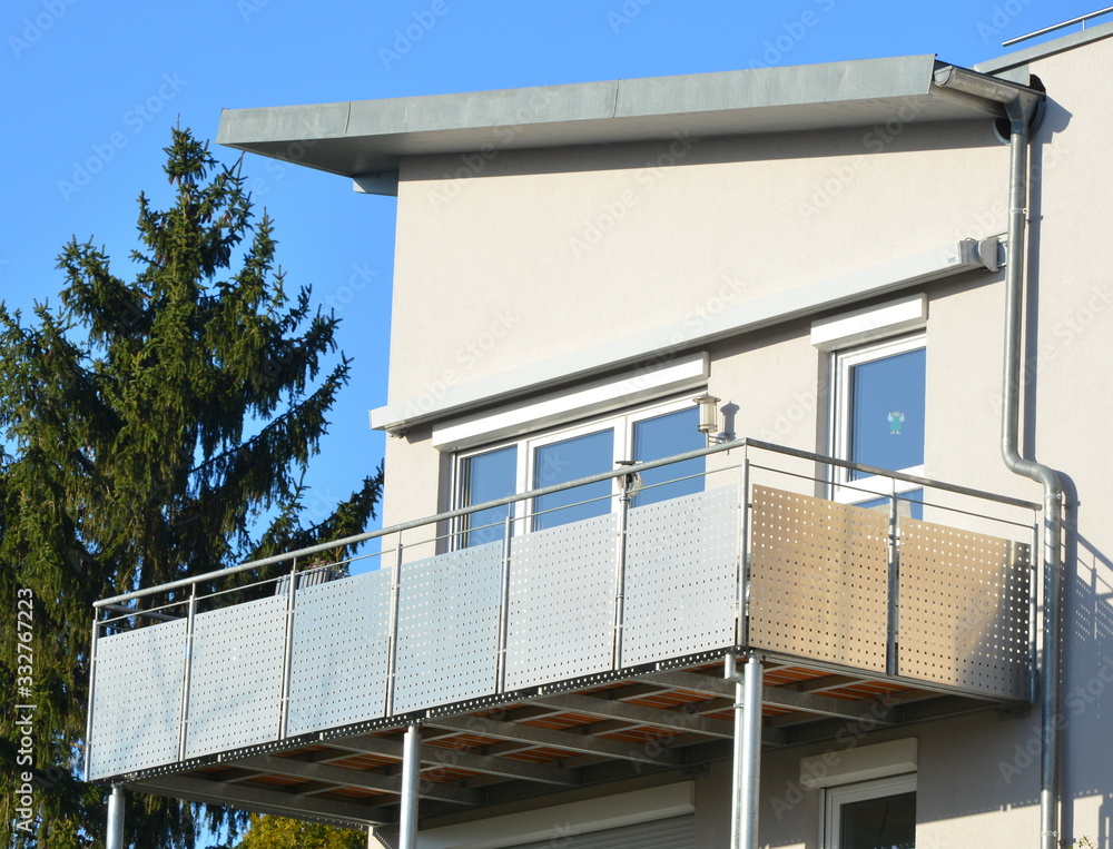 Moderner Balkon mit Edelstahl-Geländer und Edelstahl-Sichtschutzplatten an Neubau-Hausfront Moderner Balkon mit Edelstahl-Geländer und Edelstahl-Sichtschutzplatten an Neubau-Hausfront
