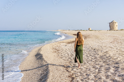 Fototapeta Naklejka Na Ścianę i Meble -  Woman walks on Sunny day at Ai Giannis (Gyra) beach on the island of Lefkada, Greece