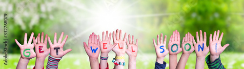 Children Hands Building Colorful English Word Get Well Soon. Sunny Green Grass Meadow As Background
