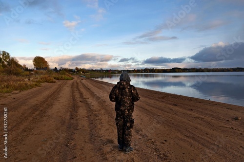 A man wandering along the shore. Late fall. photo