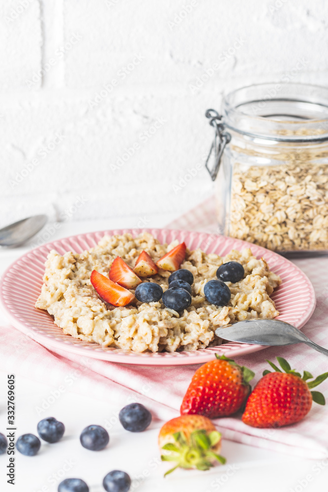 Plate of oatmeal porridge with strawberries and blueberries. Plate of oatmeal porridge with strawberries and blueberries.