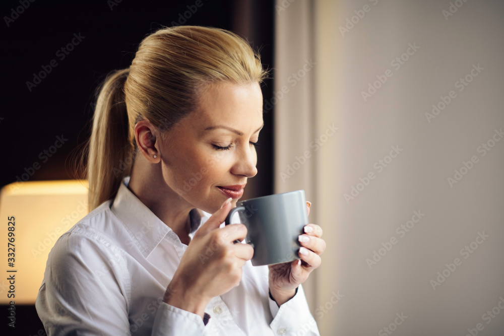 Young beautiful woman enjoying in coffee.Businesswoman working from a hotel room. Young beautiful woman enjoying in coffee.Businesswoman working from a hotel room.