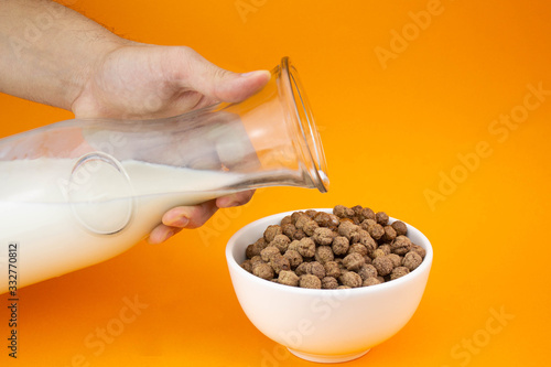 Hombre sirviendo cereal y leche de chocolate
