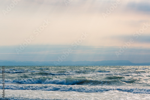 Sea surf with waves in beautiful sunlight