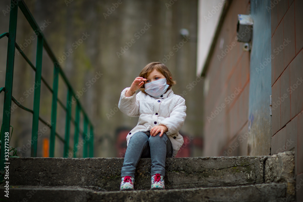 Fototapeta premium little girl on a walk in a medical mask