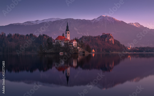 Beginning Of The Day At Lake Bled In Winter, Slovenia. Pinky Sunrise With Perfect Reflection Of Julian Alps And St. Marys Church Of The Assumption.Slovinian Landscape With Bled Castle ( Blejski grad ) photo