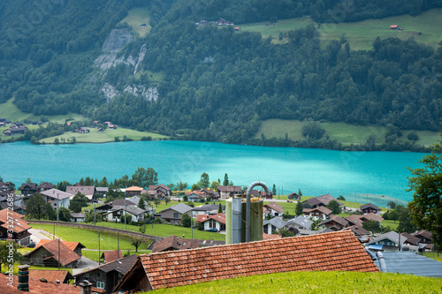 View of the roofs of traditional swiss houses swiss village Lungern. Stunning turquoise Lake Lungerersee with clear water, canton of Obwalden, Switzerland. Incredibly bewitching and calm place. photo