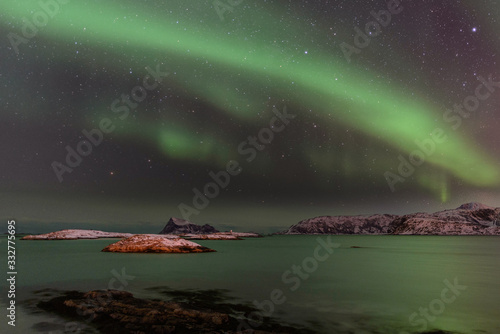 Aurora boreal sobre Sommarøy en la isla de Kvaløy, norte de Noruega en el mes de febrero photo