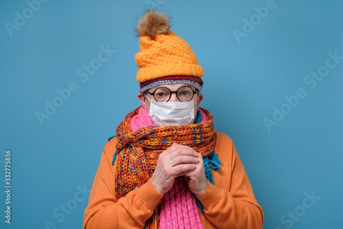 Konstfotografi Mature man with medical mask as protection from Covid-19 and funny hat glasses and scarf