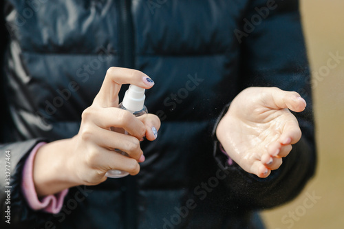 Woman hands using wash hand sanitizer spray dispenser, against new coronavirus at public place. Antiseptic, hygiene and healthcare concept.
