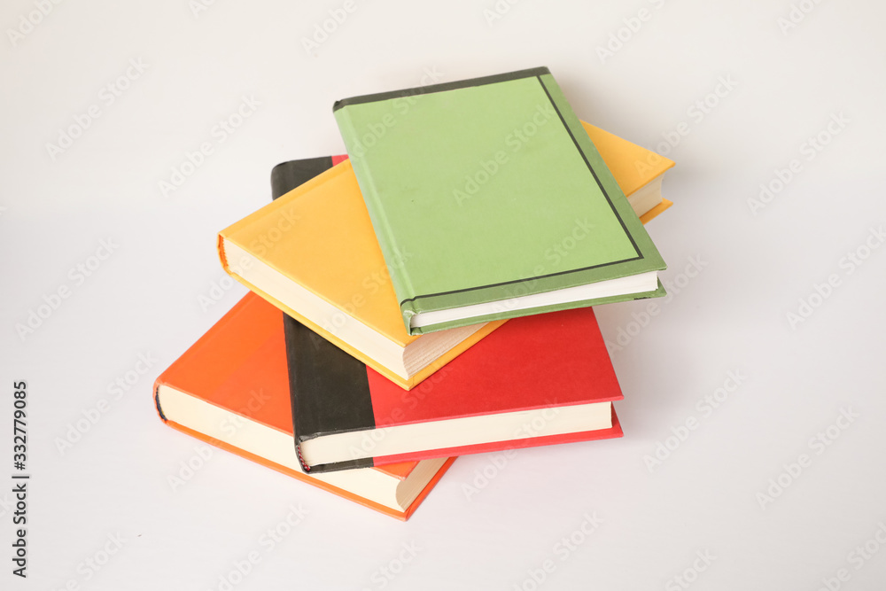A stack of colourful books isolated on a white background A stack of colourful books isolated on a white background