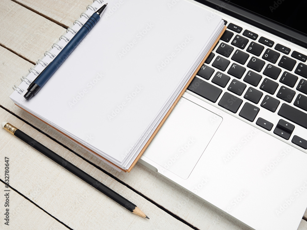 Workplace - laptop, notebook, pen, and pencil for remote work on a white wooden table. Freelance desktop for home or office. Background with copy space. Workplace - laptop, notebook, pen, and pencil for remote work on a white wooden table. Freelance desktop for home or office. Background with copy space.