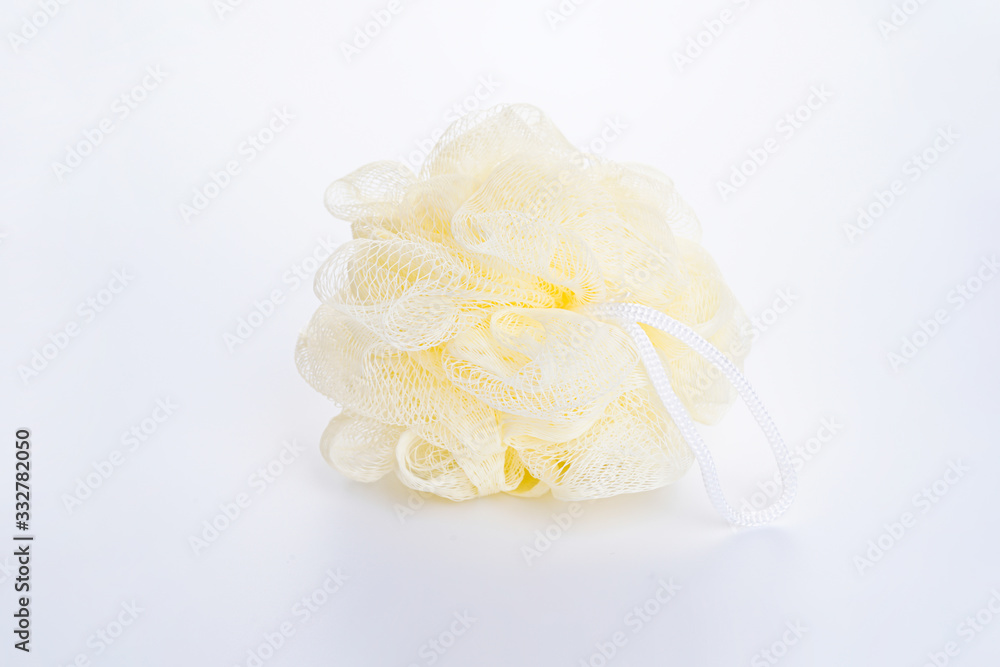 Soft yellow bath puff or sponge on a white background.