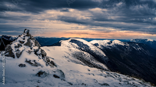 Lever de soleil blafard sur montagne enneigée et ciel sombre © Jérémie