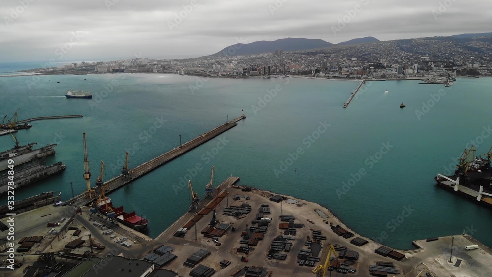 Bird eye panoramic aerial view of cargo port with hundreds of ships loading export and import goods and thousands of containers in harbor.