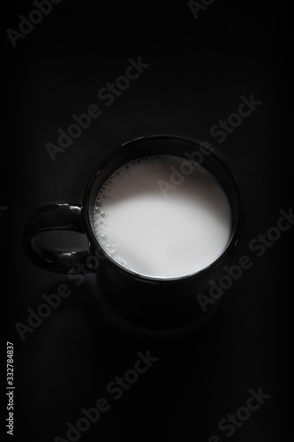 taza negra en fondo negro y liquido blanco