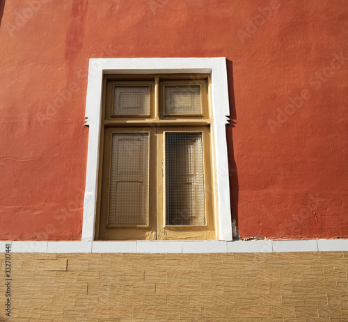 A simple single window in a brown wall.