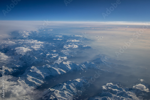View from a cockpit of a commercial airliner airplane over a beautiful mountain range