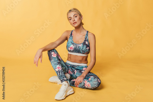 Beautiful young blonde woman in nice spring dress, posing in studio. Sexy and fashion photoshoot.