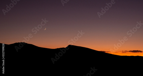 Wallpaper Mural Crescent moon and sunset over silhouette of desert ridge on fall evening Torontodigital.ca