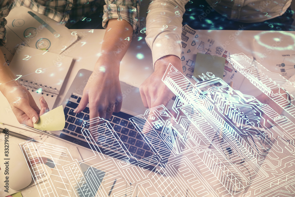 Double exposure of man and woman working together and the buildings hologram drawing. Computer background. Top View. Smart city concept. Double exposure of man and woman working together and the buildings hologram drawing. Computer background. Top View. Smart city concept.