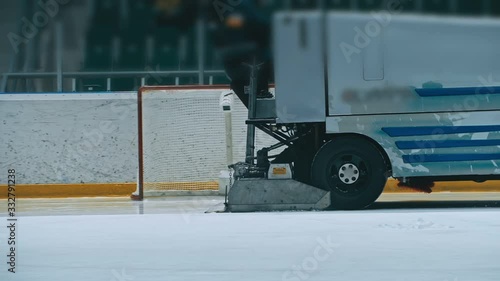 Zamboni resurfacing an indoor skating rink. Slow Motion. Ice resurfacer cleaning ice, machine cleaning and polishing smooth icerink. Ice harvester or restores ice.
