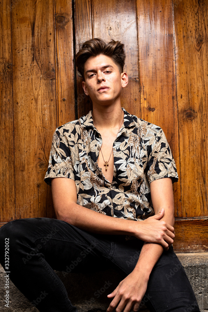 Portrait of young model with tough guy look with wooden door background. Portrait of young model with tough guy look with wooden door background.