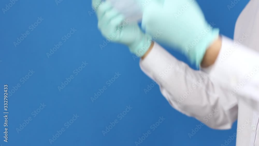 side view on man's hands in surgery gloves, show medical mask and puts it, prevention or protection of virus coronavirus or pollution, doctor or patient demonstrate, blue background side view on man's hands in surgery gloves, show medical mask and puts it, prevention or protection of virus coronavirus or pollution, doctor or patient demonstrate, blue background