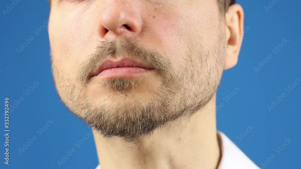 close-up part of male face, demonstrate how to remove used medical mask, rules of hygiene to prevention or protection of virus or pollution, blue background close-up part of male face, demonstrate how to remove used medical mask, rules of hygiene to prevention or protection of virus or pollution, blue background