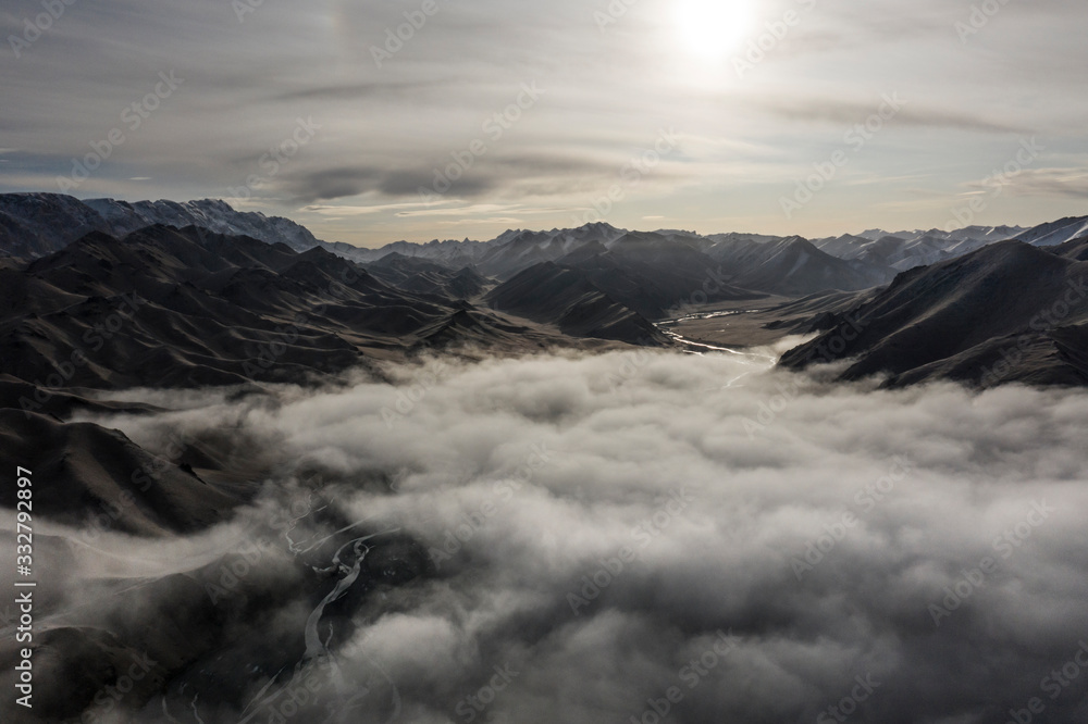 Aerial landscape short after autumn sunrise over the Kurmduk Valley in the vicinity of the Ak-Sai Valley and Kol Suu lake, showing the Kurumduk River through the Kyrgyz Tian Shan Mountains