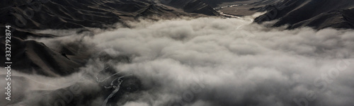 Aerial landscape short after autumn sunrise over the Kurmduk Valley in the vicinity of the Ak-Sai Valley and Kol Suu lake, showing the Kurumduk River through the Kyrgyz Tian Shan Mountains photo