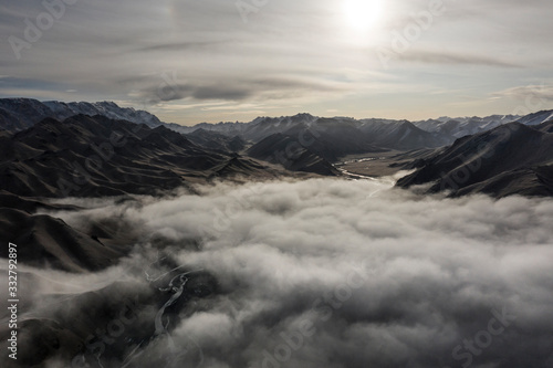 Aerial landscape short after autumn sunrise over the Kurmduk Valley in the vicinity of the Ak-Sai Valley and Kol Suu lake, showing the Kurumduk River through the Kyrgyz Tian Shan Mountains