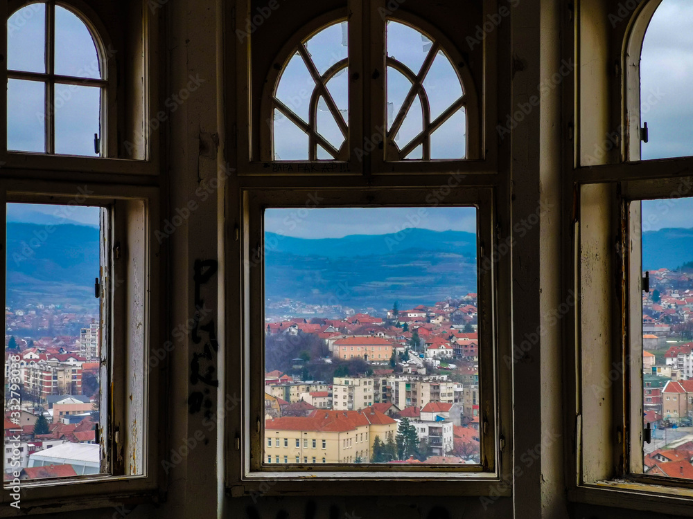 A look through 3 windos on city in background, windows have round tops and no glass A look through 3 windos on city in background, windows have round tops and no glass