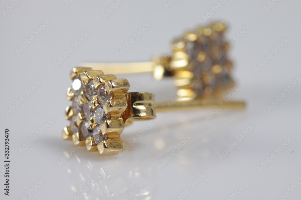 Macro shot of square gold ear ring on an isolated background Macro shot of square gold ear ring on an isolated background