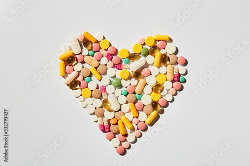 Colorful assorted heart shaped pills pattern flat lay of medicine pills colorful medicine on white background. Health care concept