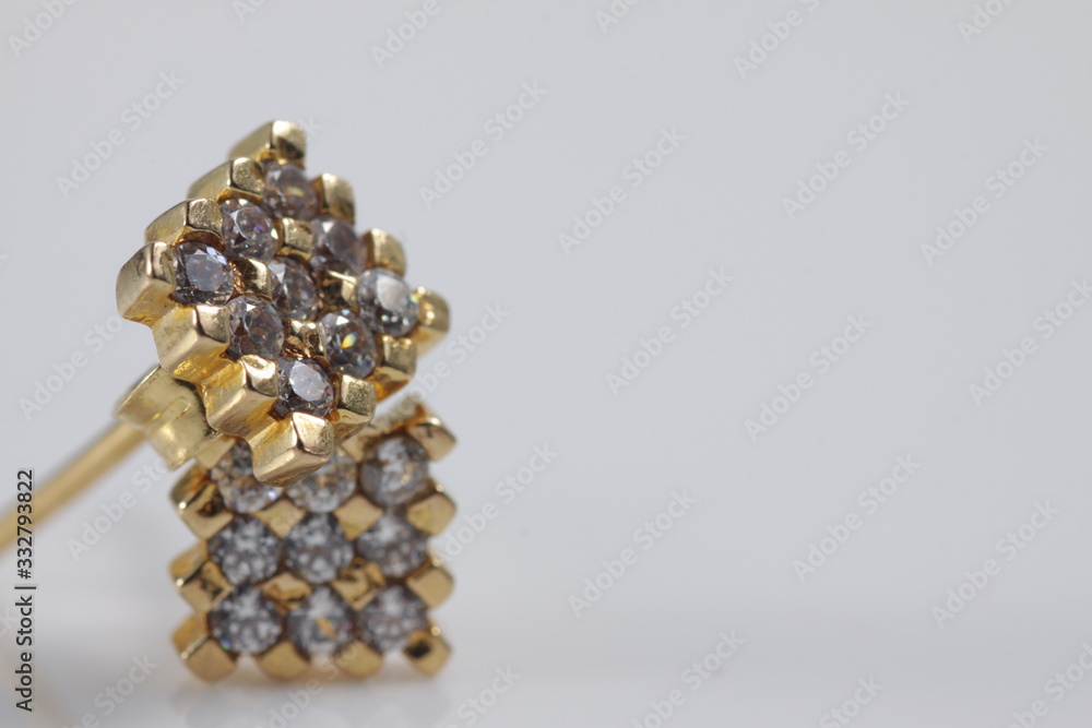 Macro shot of square gold ear ring on an isolated background Macro shot of square gold ear ring on an isolated background