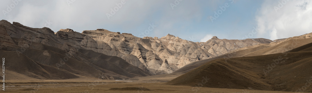 Landscape panorama of cahedral type rock mountain wall along the Kulak-Ashu pass connecting Baetov and Orto-Sirt with Tash-Rabat