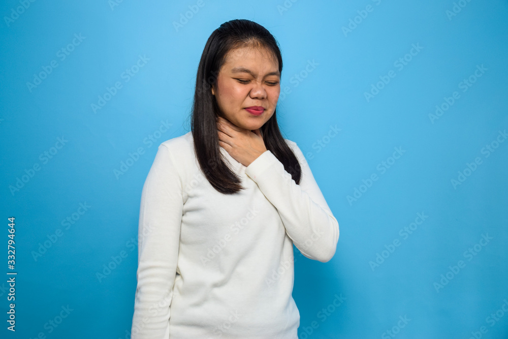 Portrait of Young beautiful asian women using white T-shirt with blue isolated background, women sore throat, COVID-19, Corona Virus Portrait of Young beautiful asian women using white T-shirt with blue isolated background, women sore throat, COVID-19, Corona Virus