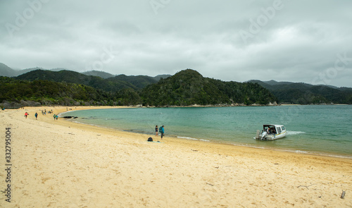 People walking on beach next to forest at Anchorage Bay in Abel Tasman New Zealand © Paul