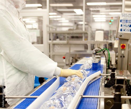 Assembly line medical tech worker making IV bags. 